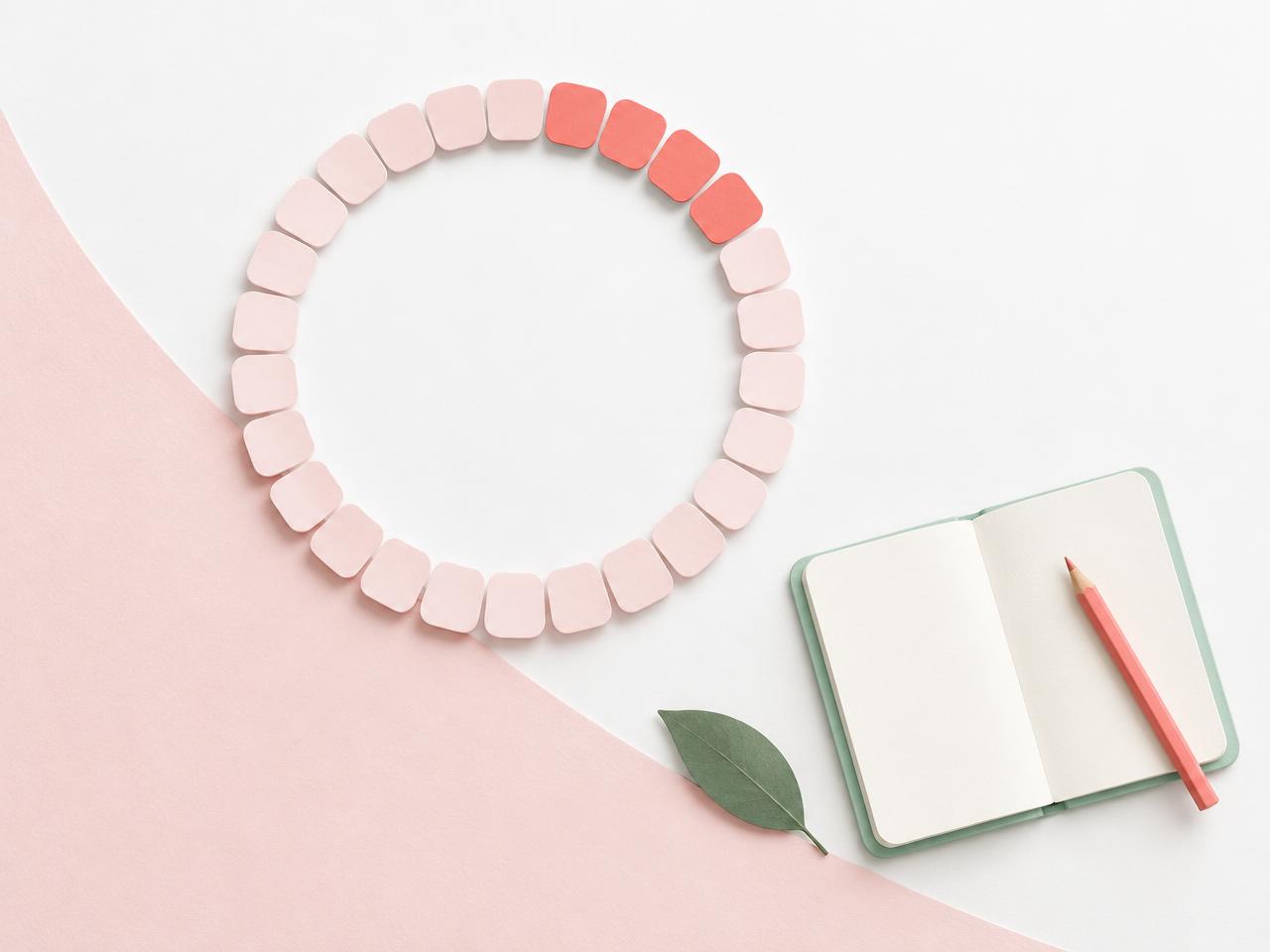 Paper calendar ring beside a journal and pencil